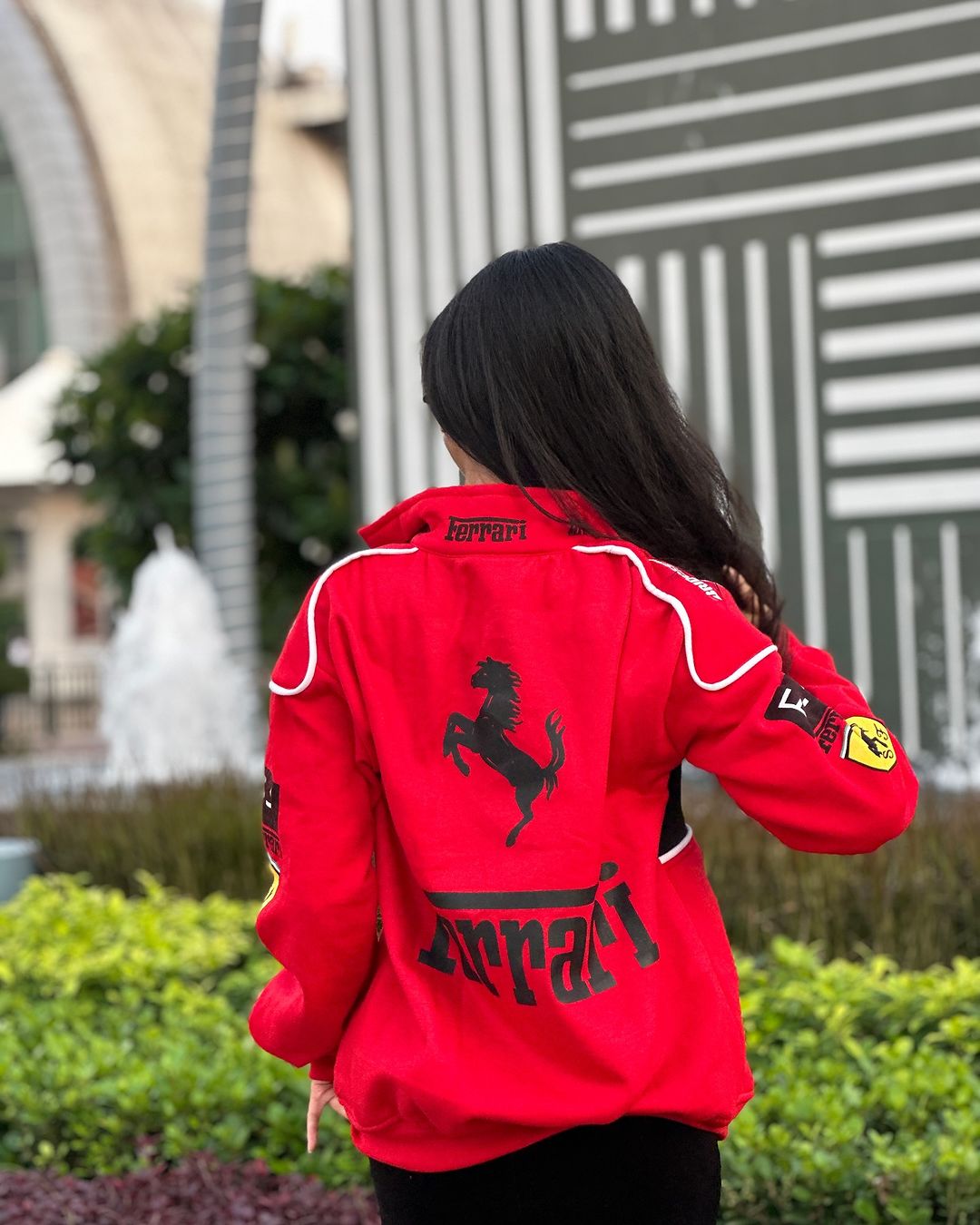 Red racing jacket with white trim, large back silhouette graphic, and sleeve patches