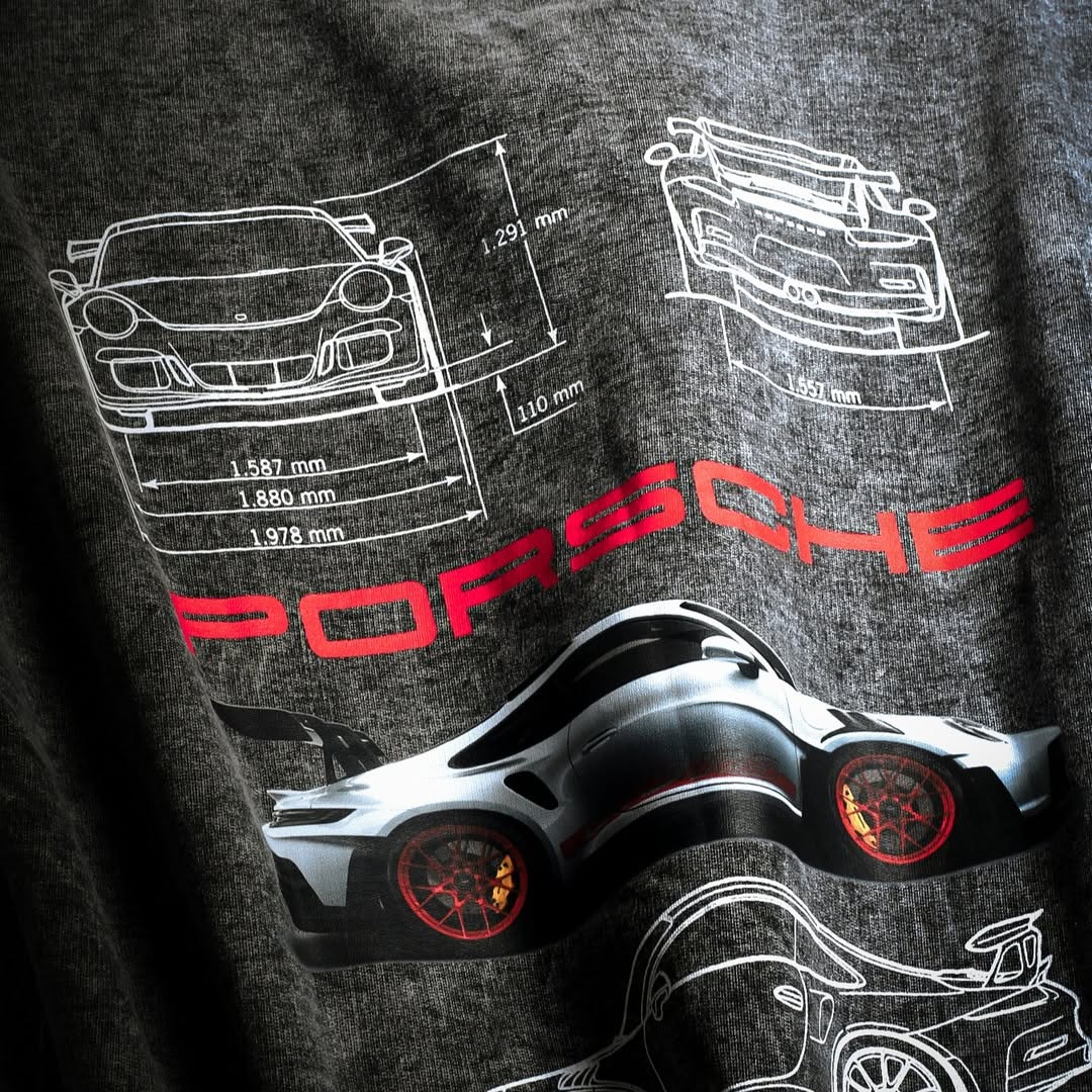 Acid-wash T-shirt close-up with white line drawings, red PORSCHE text, and car image