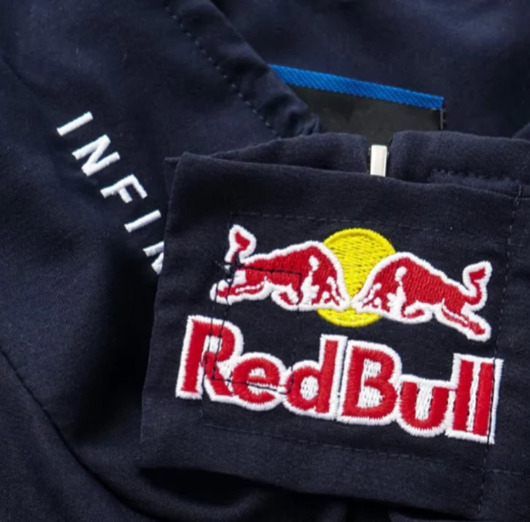 Close-up of embroidered Red Bull logo patch on dark blue jacket