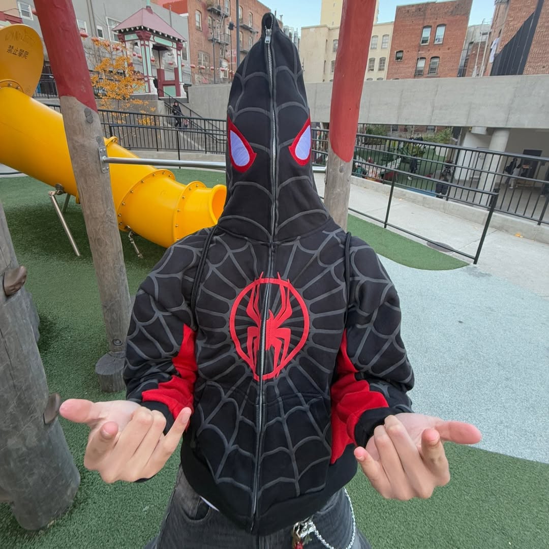 Black zip-up hoodie with red spider web and large hood emblem, front close-up.