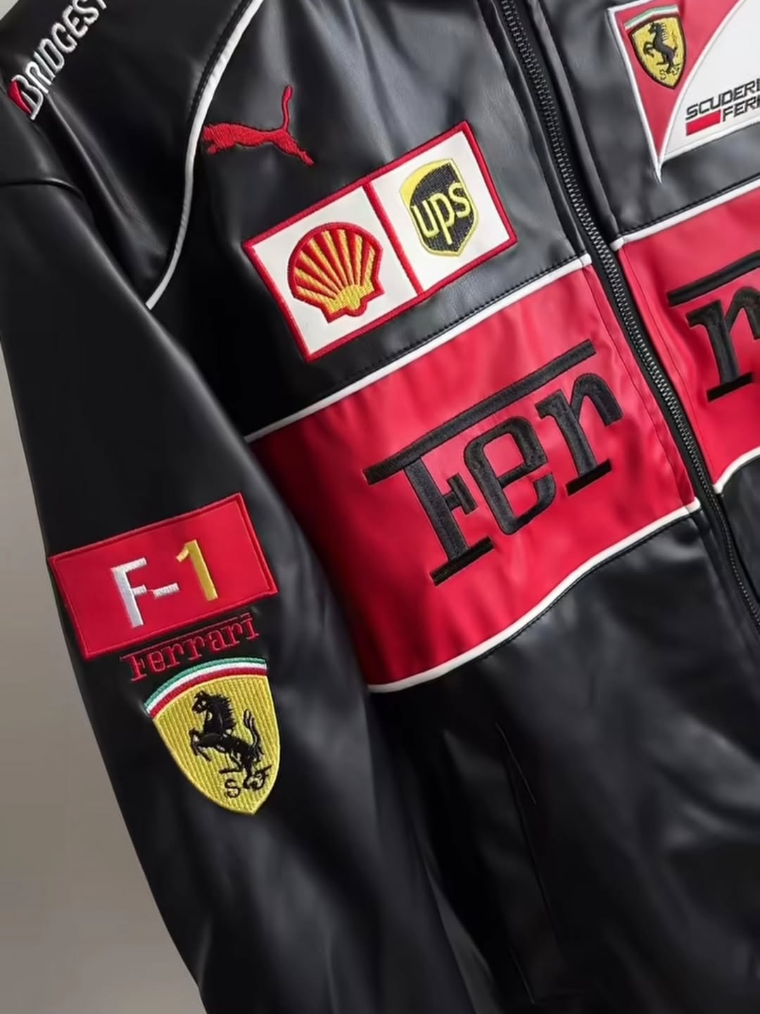 Black and red leather racing jacket with Puma logo and sponsor patches on chest