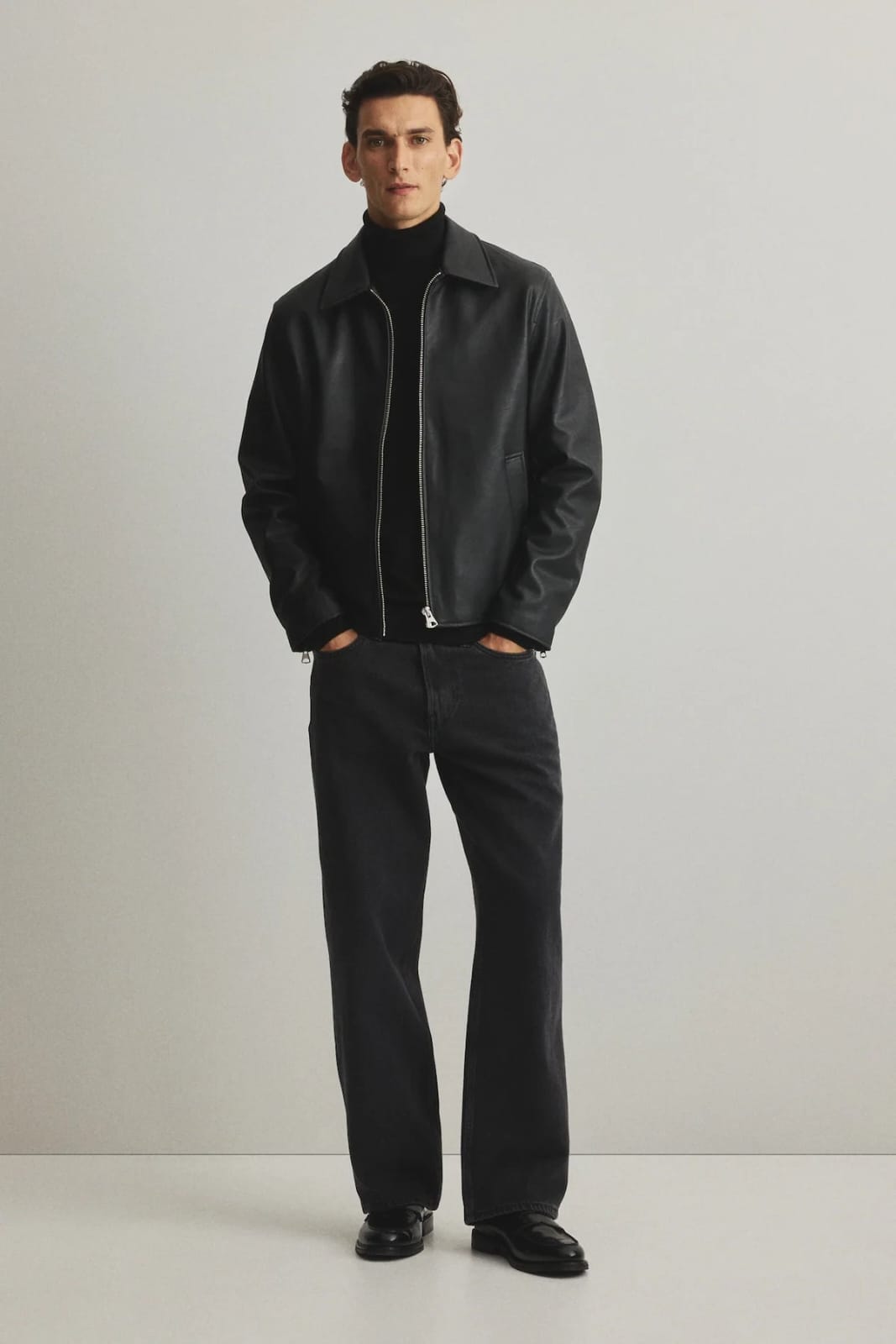 Black oversized leather zip-up jacket with stand collar, front view on model