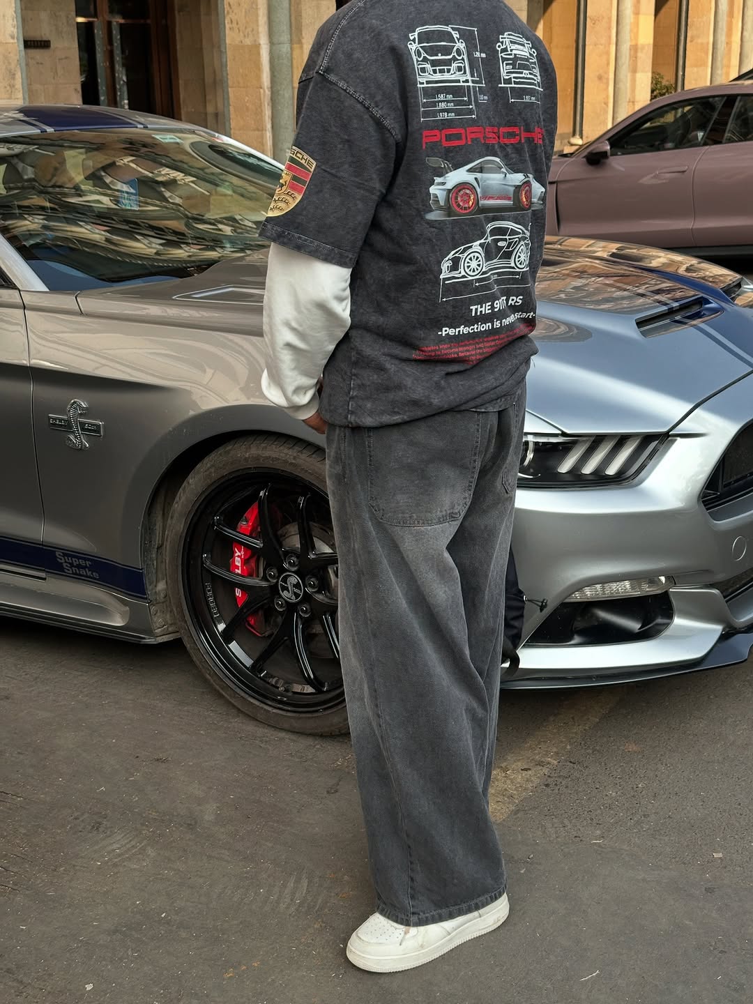 Dark acid-wash T-shirt on person with Porsche graphic on the upper back