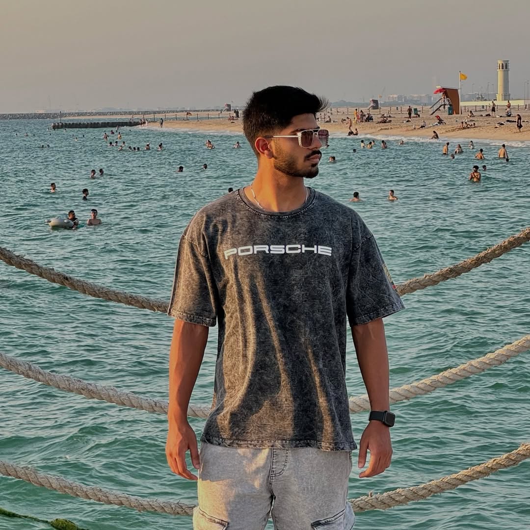 Gray acid-wash T-shirt on person with small PORSCHE logo on the chest
