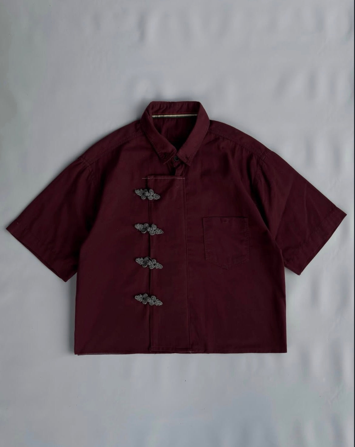 Close-up of burgundy Chinese shirt with frog button detailing