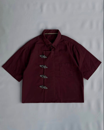 Close-up of burgundy Chinese shirt with frog button detailing