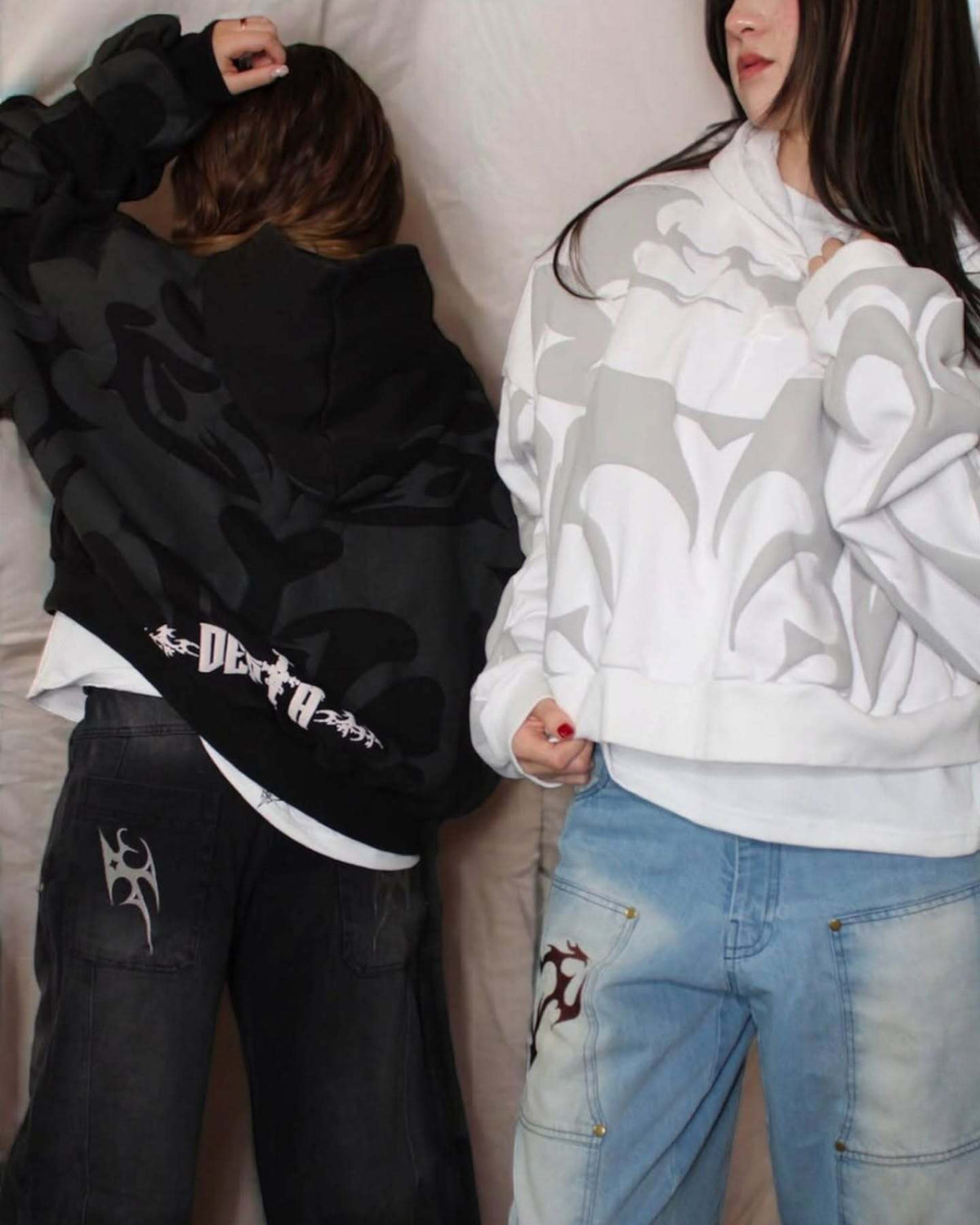 Model wearing black and white graphic pullover hoodies with tribal prints