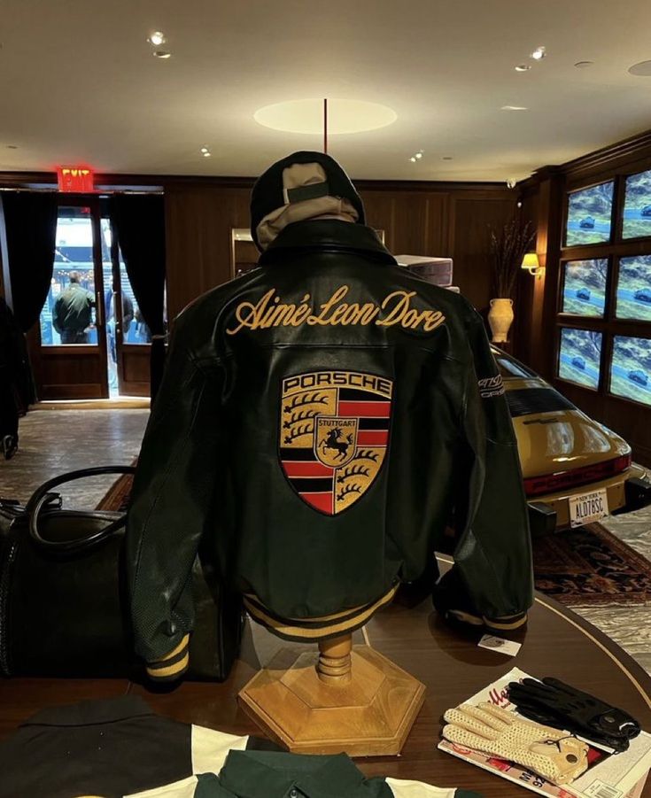 Green Porsche racing jacket with Aimé Leon Dore script and large back logo.