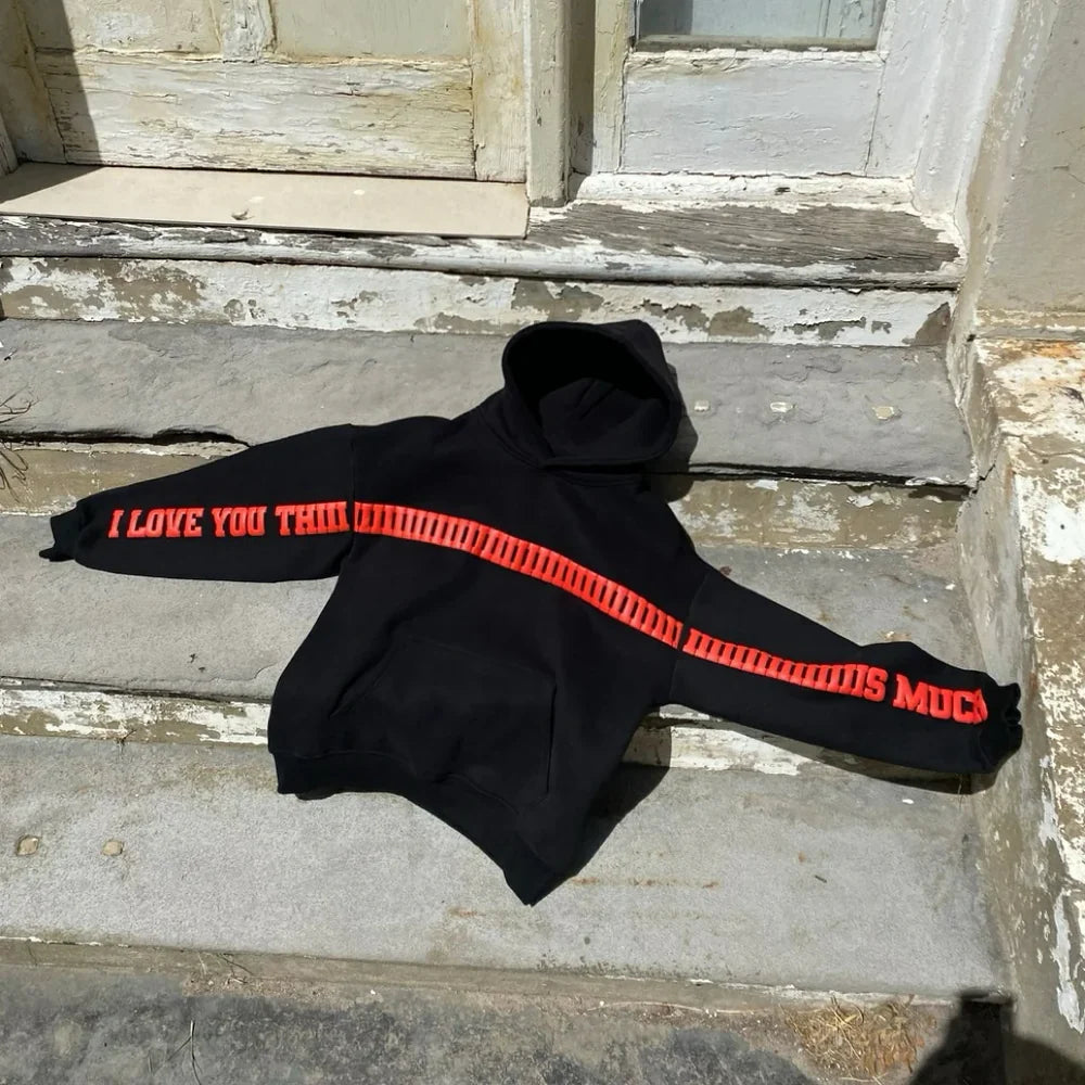 Black oversized hoodie with red ‘I LOVE YOU THIS MUCH’ text, laid flat