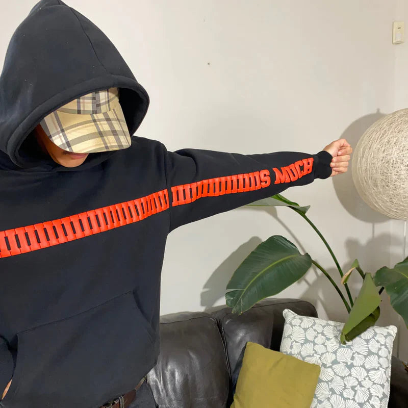 Black oversized hoodie with red graphic text; plaid-lined hood and long sleeves