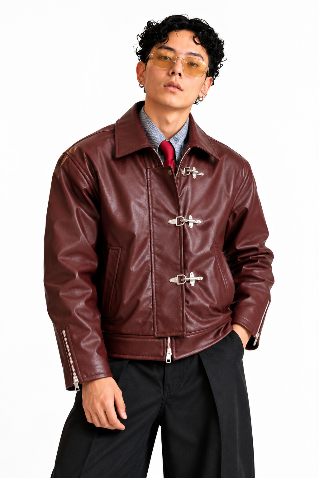 Side angle of a men's burgundy leather-look jacket with silver buckle detailing, structured collar and zippered cuffs.