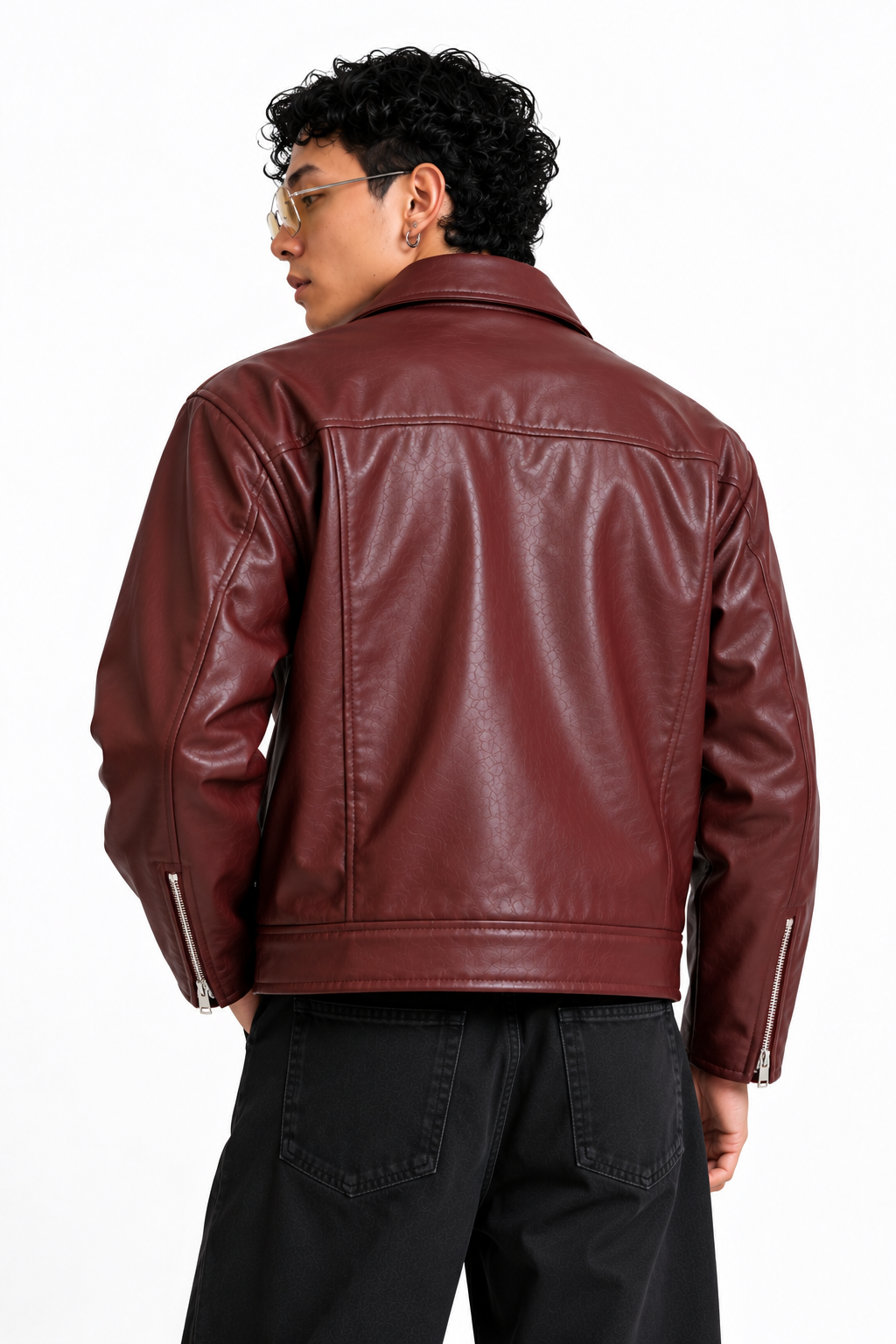 Male model adjusting sunglasses while wearing Mercywear burgundy leather-look jacket with silver metal buckles and vintage streetwear styling.