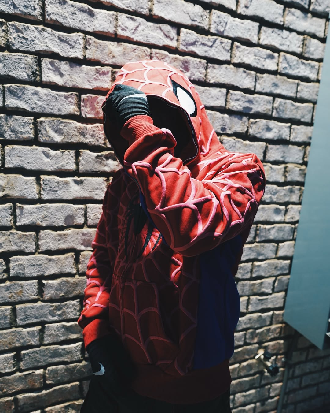 Red spider-web zip hoodie with drawstring hood and blue sleeve accents
