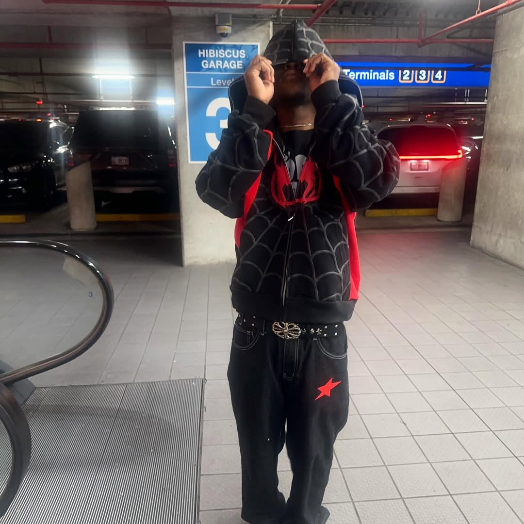 Black zip-up hoodie jacket with red spider chest print and web design, front view.